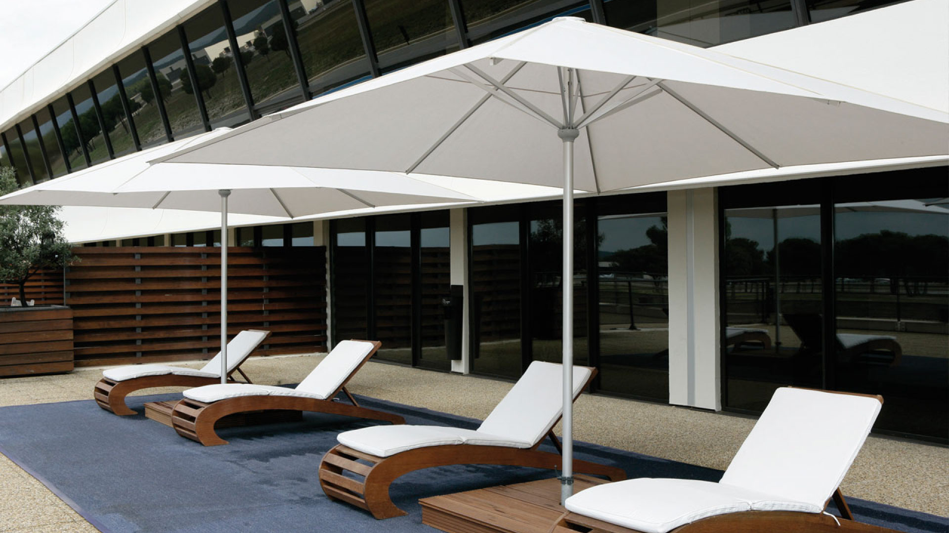 Sonnenschirme über Liegen auf einer Hotelterrasse
