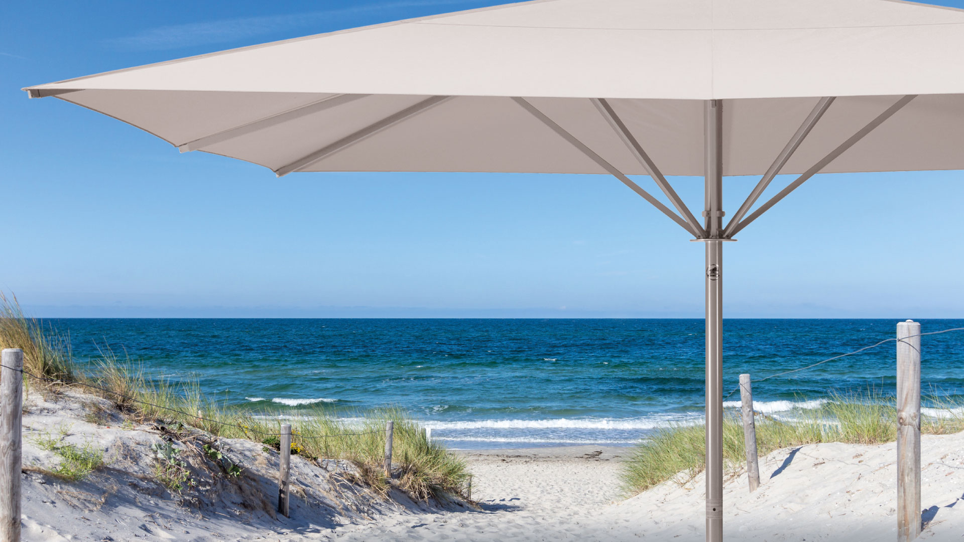 Premium-Sonnenschirm mit hellem Tuch an einem Strand