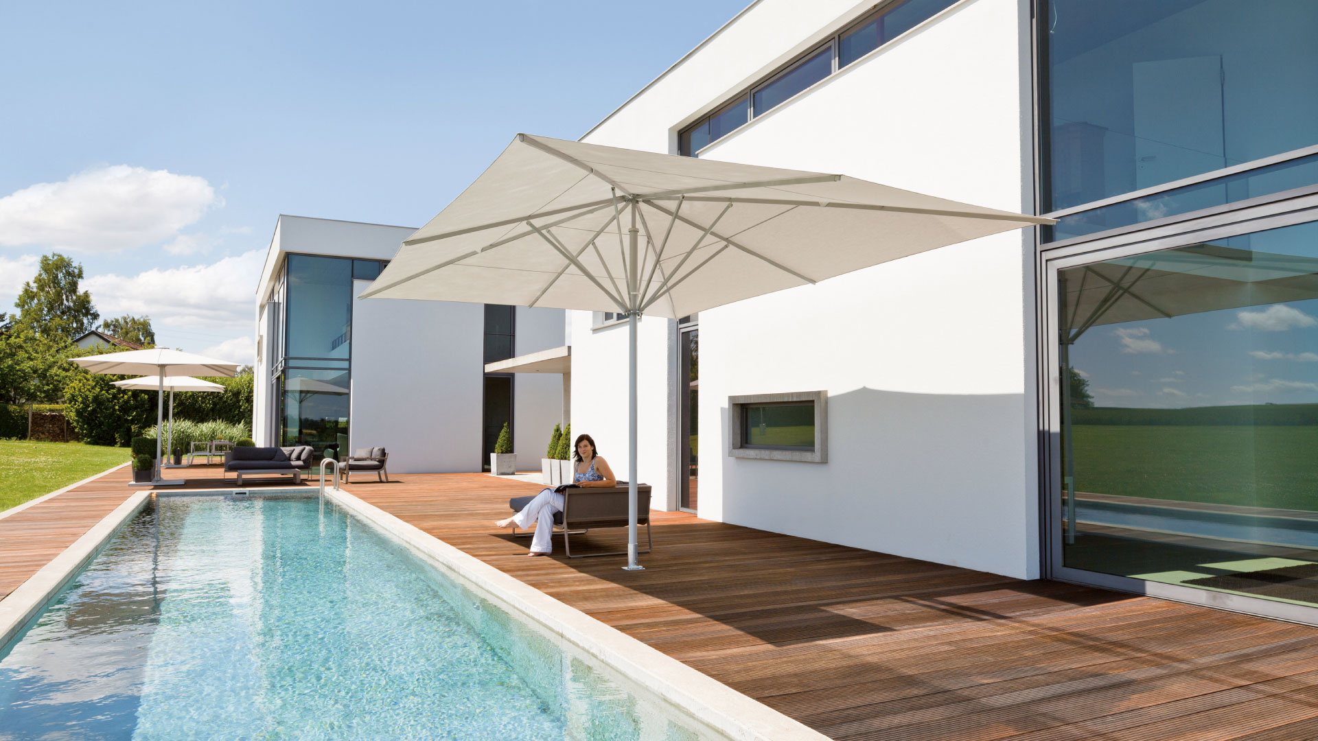 Premium-Sonnenschirm am Pool eines modernen Wohnhauses